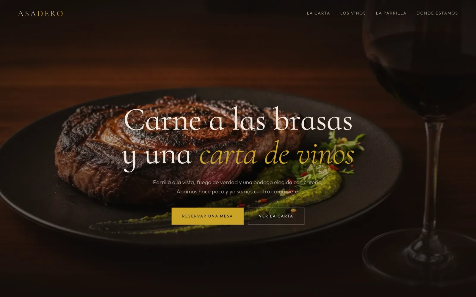 Landing para una parrilla de autor, con el titular "Carne a las brasas y una carta de vinos" sobre un ojo de bife cortado sobre plato negro con chimichurri, una copa de vino tinto al lado, en una mesa de madera oscura con luz cálida.